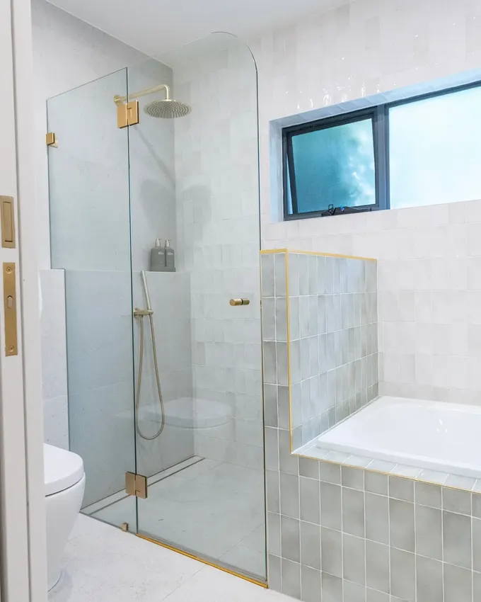 Banyo ve duşu ayıran alçak duvar, alanı sıkıştırmadan bölme sağlar. Temiz ve şık bir tasarım sunar.