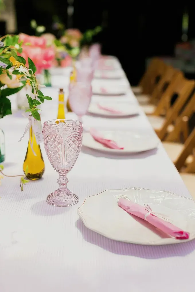 Pastel kadehler, pembe peçeteler, küçük tomurcuk vazolar, temiz masa örtüsü—ferah, kolay, fotoğraflık.