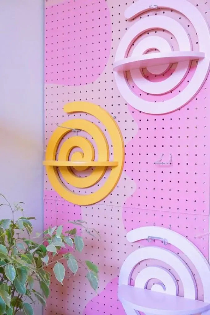 Pembe tonlarının ve eğlenceli dalgalı rafların kombinasyonu ile yapılmış renkli bu dalgalı pegboard, dopamin yükselten ev ofisleri için güzel bir fikir.