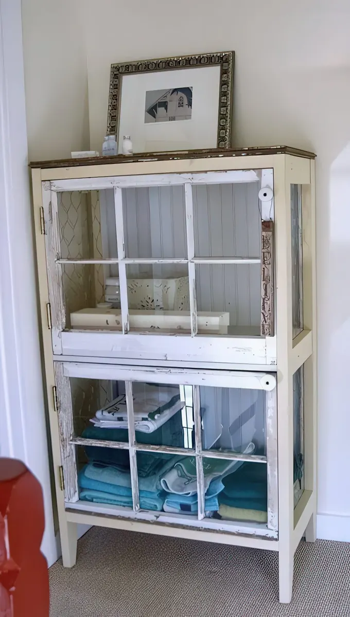 Kapakları eski pencere pervazlarından yapılmış eskimiş şıklıkta bir cam dolap, vintage banyolar için harika bir fikir.