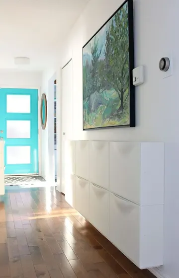 Beyaz IKEA Trones neredeyse beyaz duvarla bütünleşiyor, uzun ve dar koridorlar için ideal bir çözüm.