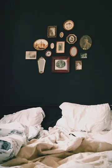 Havalı yatak odası, küçük sanat ve aynalardan oluşan vintage galeri duvarıyla daha etkileyici görünüyor.