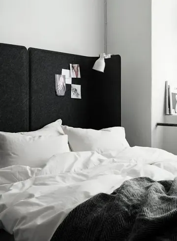 İki IKEA Bekant ofis paneli birleştirilerek yüksek ve sade bir başlık yapıldı. Modern ve cesur bir yatak odası odak noktası.