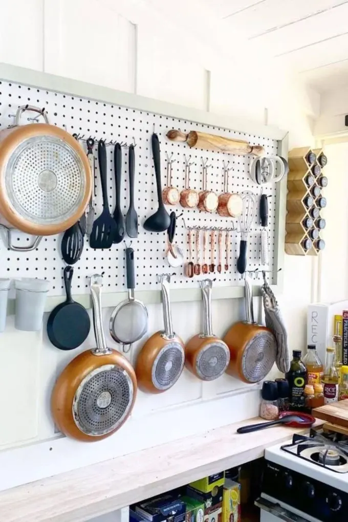 Yatay pegboard, kancalarla donatılmış ve tüm tava ile mutfak gereçlerini tutuyor.